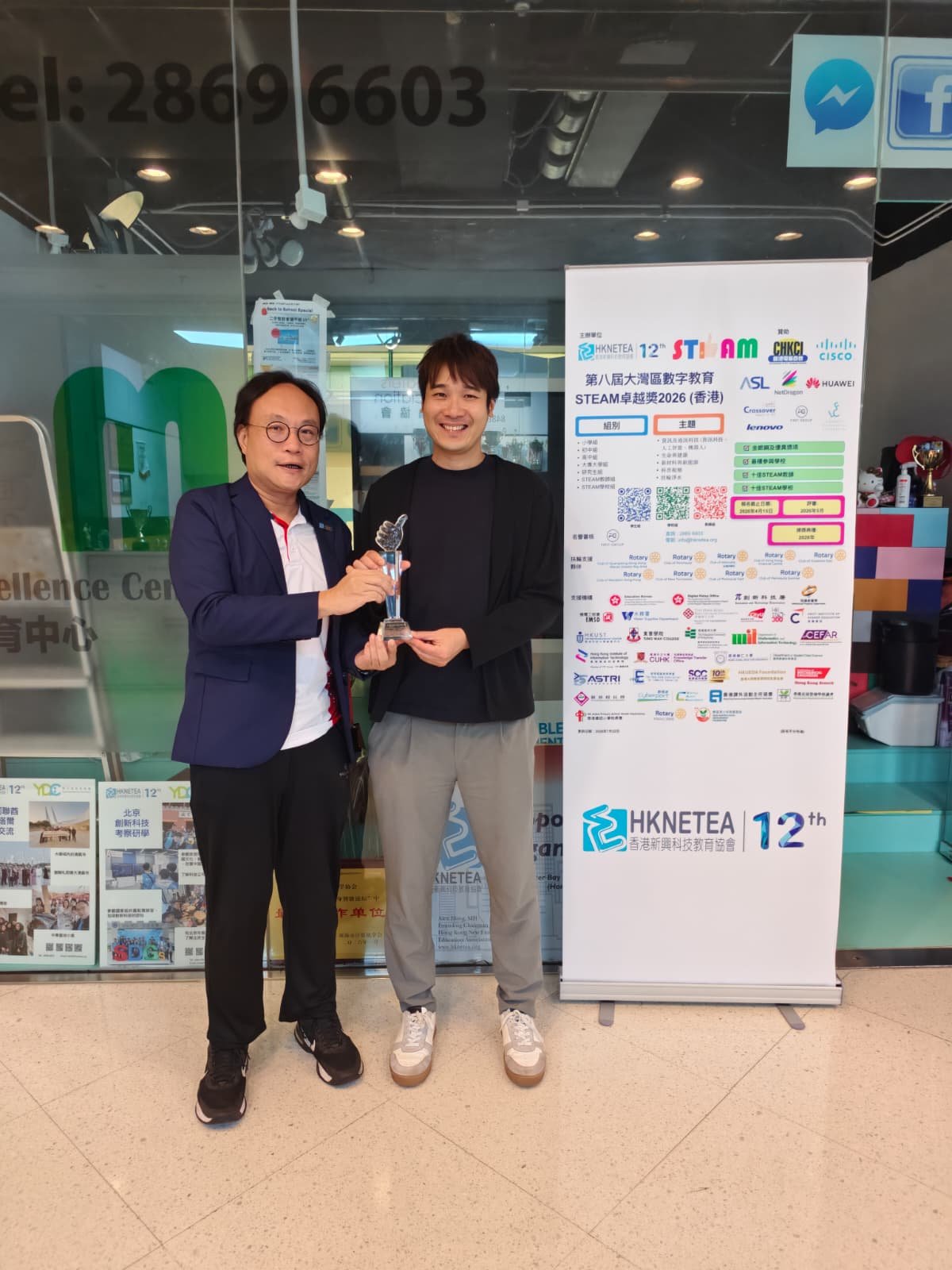 Ir. Dr. Tang Yuk-ming receiving the Top 10 STEAM Teacher Award at the 2026 DESEA event, standing beside a HKNETEA event banner.